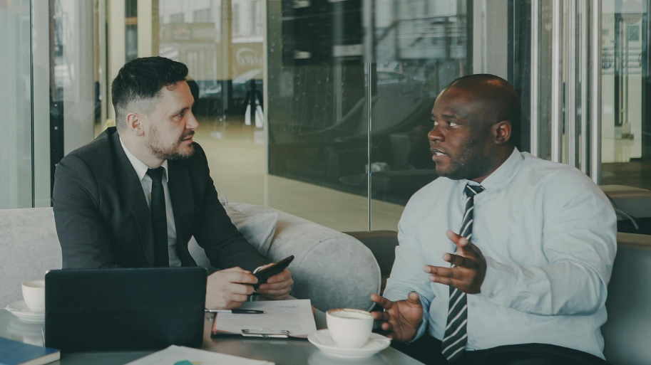 Two businessmen chatting in an office environment.