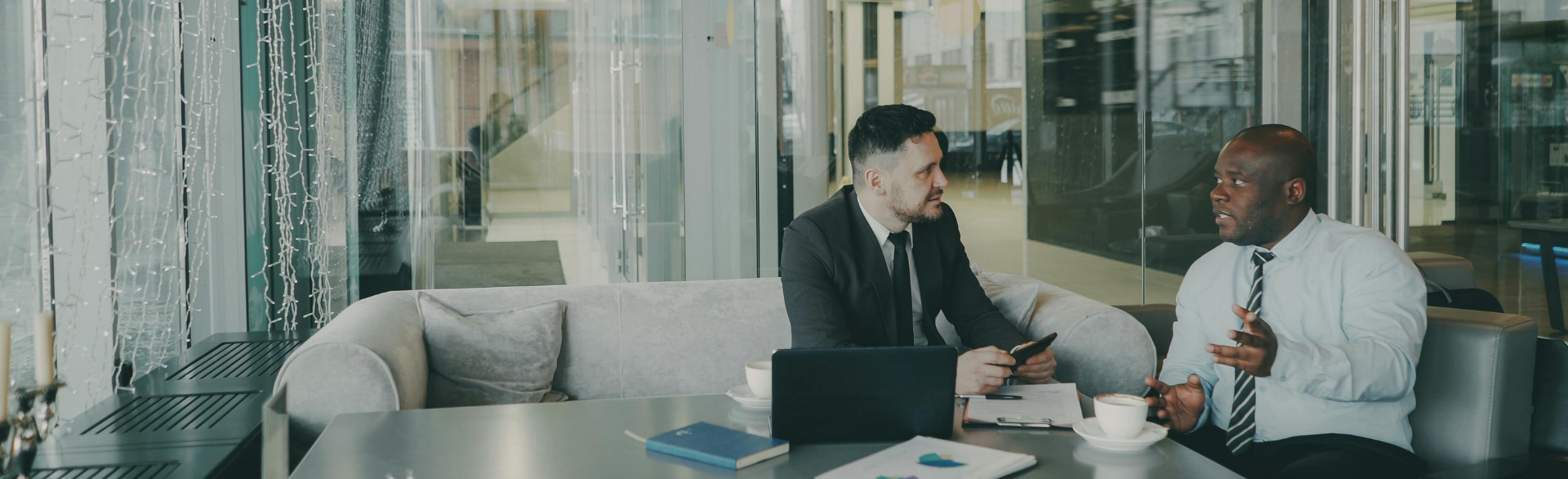 Two businessmen chatting in an office environment.
