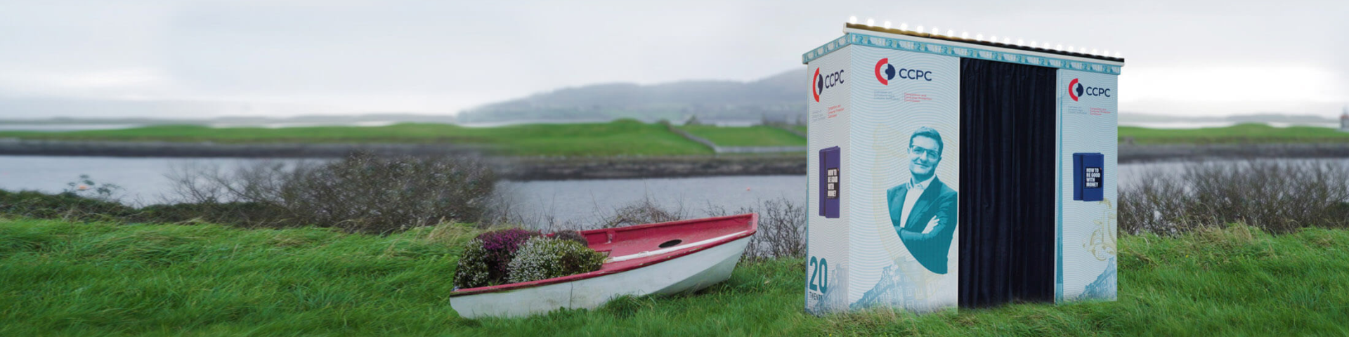 CCPC branded photobooth beside a red boat next to a lake