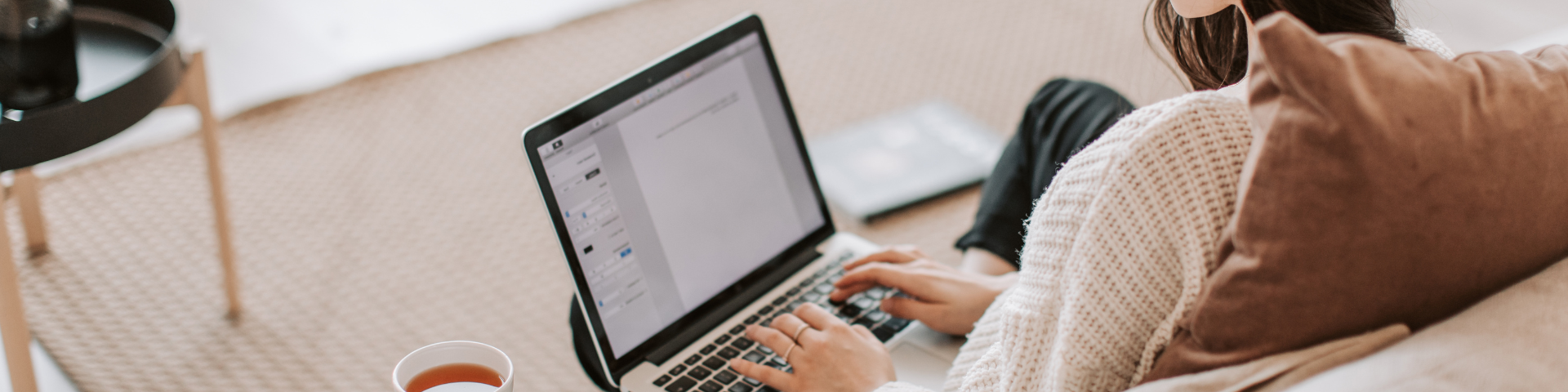 A person is typing a letter on a laptop
