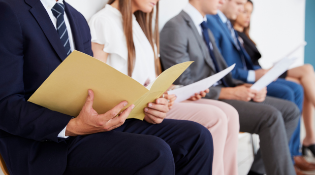 People preparing for an interview reading folders in a waiting room