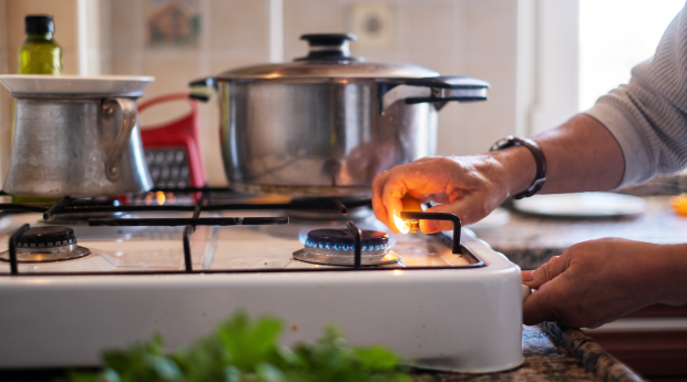 A person lights a gas hob