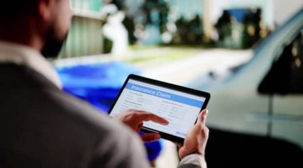 Man on tablet screen filling out an insurance claim form.