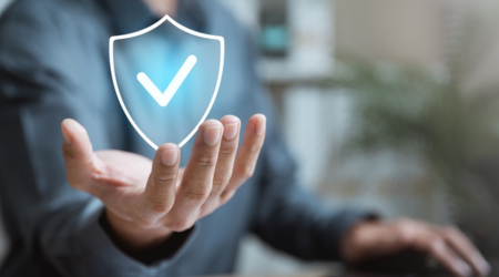 Man holding a hand out while a shield icon with a tick inside hovers above.