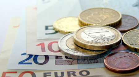 Euro notes and coins laid out on a table.