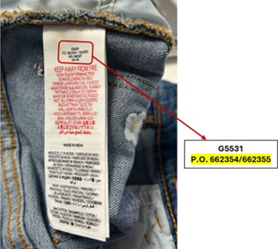 NEXT Retail Limited Boden Wide Leg Trousers Jeans - 2 A close-up image of a clothing care label sewn inside a pair of blue denim jeans. A red arrow is highlighting where the PO numbers are shown on the tag.