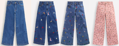 NEXT Retail trousers jeans Four pairs of wide-leg jeans displayed side by side. From left to right: Solid blue denim jeans with no visible patterns. Blue denim jeans with colorful embroidered designs including rainbows, flowers, and small figures. Blue denim jeans decorated with scattered multicolored embroidered flowers and shapes. Light pink jeans featuring an all-over pattern of small green and red floral motifs.
